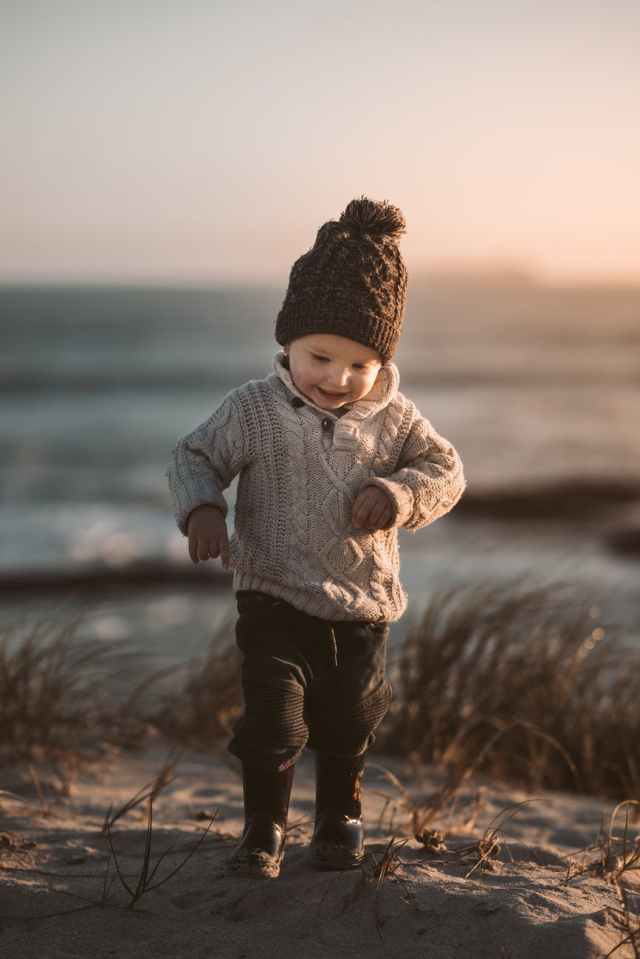 photo of toddler walking on sand